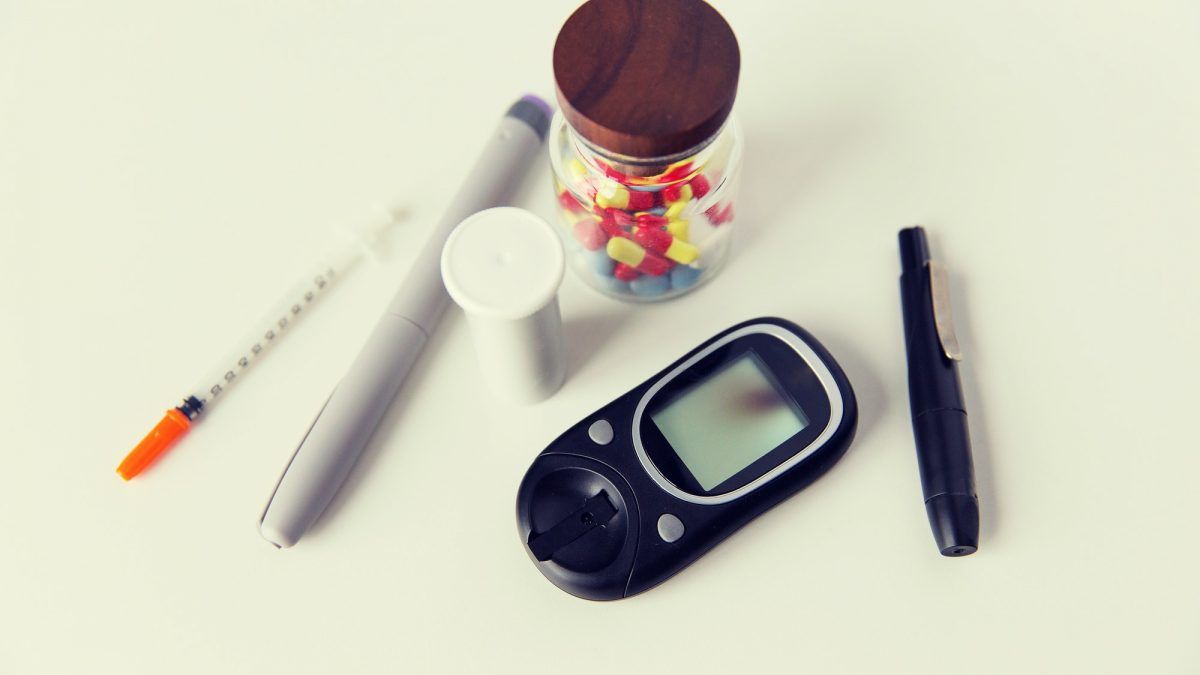 close up of glucometer insulin pen and drug pills